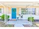 Inviting front porch features a vibrant blue door, charming decor, and stylish accents at 1433 Spring Ln, Clearwater, FL 33755