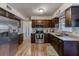 Modern kitchen with stainless steel appliances, granite countertops, and dark wood cabinets at 1433 Spring Ln, Clearwater, FL 33755