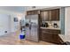 Well-lit kitchen featuring stainless steel refrigerator, dark cabinetry, and granite countertops at 1433 Spring Ln, Clearwater, FL 33755