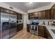 Updated kitchen with stainless steel appliances, granite countertops, dark wood cabinets, and wood-look flooring at 1433 Spring Ln, Clearwater, FL 33755