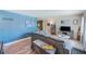 Cozy living area with stylish blue accent wall, wood floors, large sectional, and natural light at 1433 Spring Ln, Clearwater, FL 33755