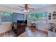 Bright living room with ceiling fan, wood floors, and natural light streaming through the windows at 1433 Spring Ln, Clearwater, FL 33755