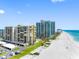 Aerial view of beachfront condos with pools, manicured lawns, and ample parking at 1480 Gulf Blvd # 1004, Clearwater Beach, FL 33767