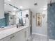 Bathroom featuring a vanity with a marble countertop, framed mirror and tiled shower with glass doors at 1480 Gulf Blvd # 1004, Clearwater Beach, FL 33767