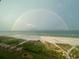 Scenic view of beach under a rainbow, showing lush dunes and ocean views at 1480 Gulf Blvd # 1004, Clearwater Beach, FL 33767