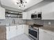 Updated kitchen featuring white cabinets, stainless steel appliances, and modern fixtures at 1480 Gulf Blvd # 1004, Clearwater Beach, FL 33767