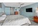 Comfortable bedroom with a large bed, fan, TV, and sliding barn doors at 1480 Gulf Blvd # 1004, Clearwater Beach, FL 33767