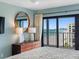 Comfortable main bedroom with light blue walls, nice lamps, dresser, TV, and balcony access at 1480 Gulf Blvd # 1004, Clearwater Beach, FL 33767