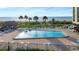 Inviting pool area featuring beach access and tiki hut lounge areas at 1480 Gulf Blvd # 1004, Clearwater Beach, FL 33767