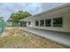 A covered patio extending to the green chain link fenced backyard with mature trees at 1509 Cherry Hills Dr, Sun City Center, FL 33573