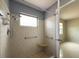 Shower stall with tiled walls, a built-in seat, safety bars and a window at 1509 Cherry Hills Dr, Sun City Center, FL 33573