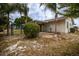 Landscaped yard and home exterior view featuring a covered patio at 1509 Cherry Hills Dr, Sun City Center, FL 33573