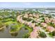 Scenic aerial perspective featuring a community with beautiful red-tiled roof homes nestled by a peaceful lake at 1532 Citrine Trl, Tarpon Springs, FL 34689