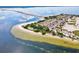 Aerial view showcases a scenic beach, causeway, and parking surrounded by crystal-clear waters at 1532 Citrine Trl, Tarpon Springs, FL 34689