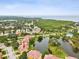 An elevated shot of a townhome with a pond in the Sunset Bay community, near lush green space and water at 1532 Citrine Trl, Tarpon Springs, FL 34689