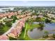 Sunset Bay townhomes surround a peaceful pond and include manicured landscaping in this appealing aerial view at 1532 Citrine Trl, Tarpon Springs, FL 34689