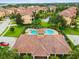 Aerial shot of community pool, hot tub, clubhouse, and surrounding colorful homes at 1532 Citrine Trl, Tarpon Springs, FL 34689