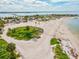 Spacious beach aerial view with a causeway, sandy areas, and ample parking under a sunny sky at 1532 Citrine Trl, Tarpon Springs, FL 34689
