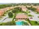 Community aerial view featuring the community pool, clubhouse, colorful houses, and pond at 1532 Citrine Trl, Tarpon Springs, FL 34689
