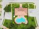 Aerial view of the pool, clubhouse, parking lot and surrounding greenery and community at 1532 Citrine Trl, Tarpon Springs, FL 34689