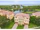 Breathtaking aerial view showcases red-tiled roofs, lush landscaping, and a tranquil lake in this residential area at 1532 Citrine Trl, Tarpon Springs, FL 34689