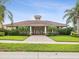 Beautiful clubhouse with a red tile roof, lush landscaping, and a brick-paved walkway at 1532 Citrine Trl, Tarpon Springs, FL 34689
