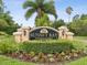 Welcome to Sunset Bay Townhomes, as shown by the community sign with lush, green landscaping at 1532 Citrine Trl, Tarpon Springs, FL 34689