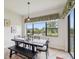 Dining area features a dark wood table and chairs with a view of the outside lake at 1532 Citrine Trl, Tarpon Springs, FL 34689