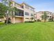 Exterior view of a multi-story home featuring a spacious lawn and private balconies at 1532 Citrine Trl, Tarpon Springs, FL 34689