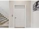 Neutral-toned hallway with a carpeted staircase and a white door at 1532 Citrine Trl, Tarpon Springs, FL 34689