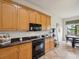Kitchen with granite counters, stainless appliances, and a view of the eating area with lake views at 1532 Citrine Trl, Tarpon Springs, FL 34689