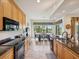 Open-concept kitchen includes granite countertops, a breakfast bar, and a dining area with outdoor views at 1532 Citrine Trl, Tarpon Springs, FL 34689