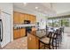 Open-concept kitchen with a breakfast bar, granite countertops, stainless steel appliances, and a dining area at 1532 Citrine Trl, Tarpon Springs, FL 34689