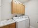 Convenient laundry room with sink, washer, dryer and cabinets at 1532 Citrine Trl, Tarpon Springs, FL 34689