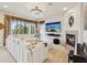 Bright living room features a fireplace, large sectional, and an oversized tv with a view at 1532 Citrine Trl, Tarpon Springs, FL 34689