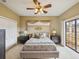 Relaxing main bedroom with soft decor, a ceiling fan, and access to a balcony at 1532 Citrine Trl, Tarpon Springs, FL 34689