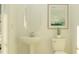 Cozy powder room boasts a pedestal sink, matching toilet, and decorative painting at 16941 Falling Waters Ct, Land O Lakes, FL 34638