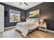 Beautiful bedroom with dark gray walls, wood floors, and a bright window with a view of the neighborhood at 18 Franklin S Ct # D, St Petersburg, FL 33711