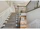Elegant staircase with carpet runner, wainscoting, and custom built-in bench with storage for organized living at 18 Franklin S Ct # D, St Petersburg, FL 33711