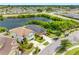 Expansive aerial view of a home next to a serene lake, surrounded by lush greenery and neighborhood streets at 1811 Redmond Brook Ln, Ruskin, FL 33570