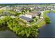 Scenic aerial view showcasing a lakefront property with a well-manicured lawn, nestled in a friendly neighborhood at 1811 Redmond Brook Ln, Ruskin, FL 33570