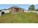 A spacious backyard featuring a well-maintained lawn and a charming covered patio area perfect for outdoor relaxation at 1811 Redmond Brook Ln, Ruskin, FL 33570