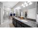 Bathroom with dual sinks, granite countertops, walk-in shower, and ample lighting at 1811 Redmond Brook Ln, Ruskin, FL 33570