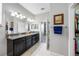 Bathroom featuring dual sink vanity, walk-in shower, and access to closet space for added convenience at 1811 Redmond Brook Ln, Ruskin, FL 33570