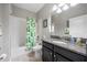 Bathroom featuring a granite countertop vanity and shower with modern fixtures and stylish shower curtain at 1811 Redmond Brook Ln, Ruskin, FL 33570