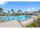 Stunning community pool with lush landscaping, palm trees, lounge chairs, and inviting amenities at 1811 Redmond Brook Ln, Ruskin, FL 33570