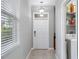 Bright foyer featuring tile flooring, modern light fixture, and a convenient laundry area at 1811 Redmond Brook Ln, Ruskin, FL 33570
