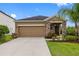 Charming single-story home with a stone-accented facade, well-manicured lawn, and attached two-car garage at 1811 Redmond Brook Ln, Ruskin, FL 33570