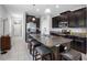 Open kitchen featuring dark wood cabinets, stainless steel appliances, and a spacious center island with bar seating at 1811 Redmond Brook Ln, Ruskin, FL 33570