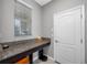 Functional laundry room with granite countertop, storage space, and a window for natural light at 1811 Redmond Brook Ln, Ruskin, FL 33570